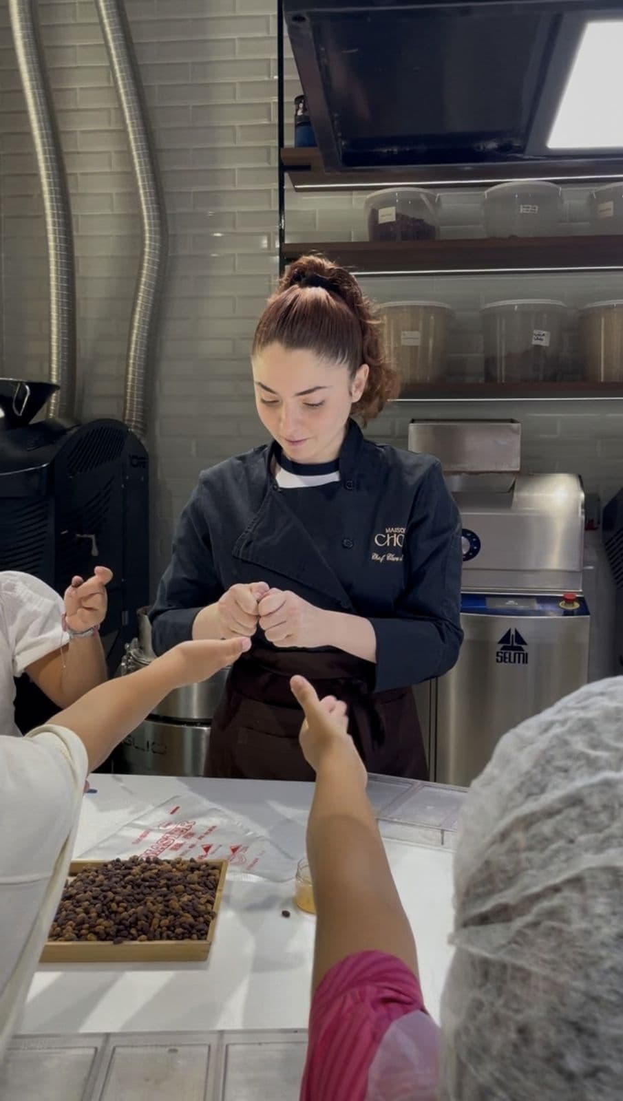 Chef Clara showing children cacao beans in the Maison Choc kitchen